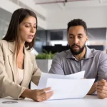 Two professionals reviewing documents together, discussing options related to tradelines for sale and credit building strategies.