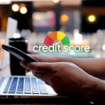A person using a smartphone in front of a laptop, with an overlaid credit score dial icon illustrating tips to boost your credit score.